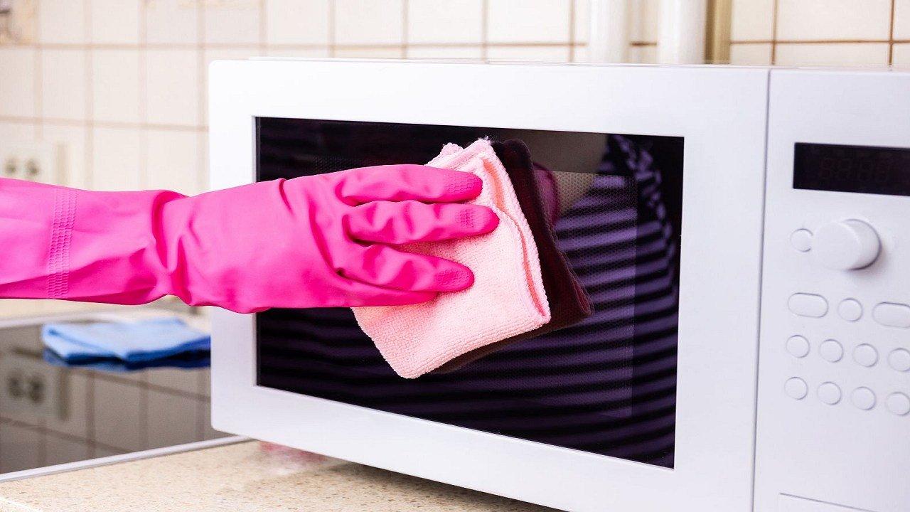 How can I clean a microwave oven effectively?