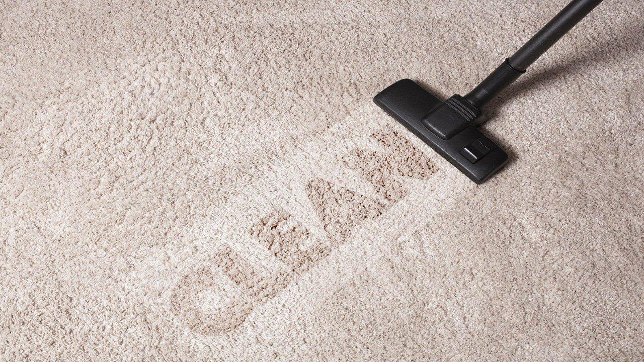 How do I remove stains from a carpet using a vacuum cleaner?